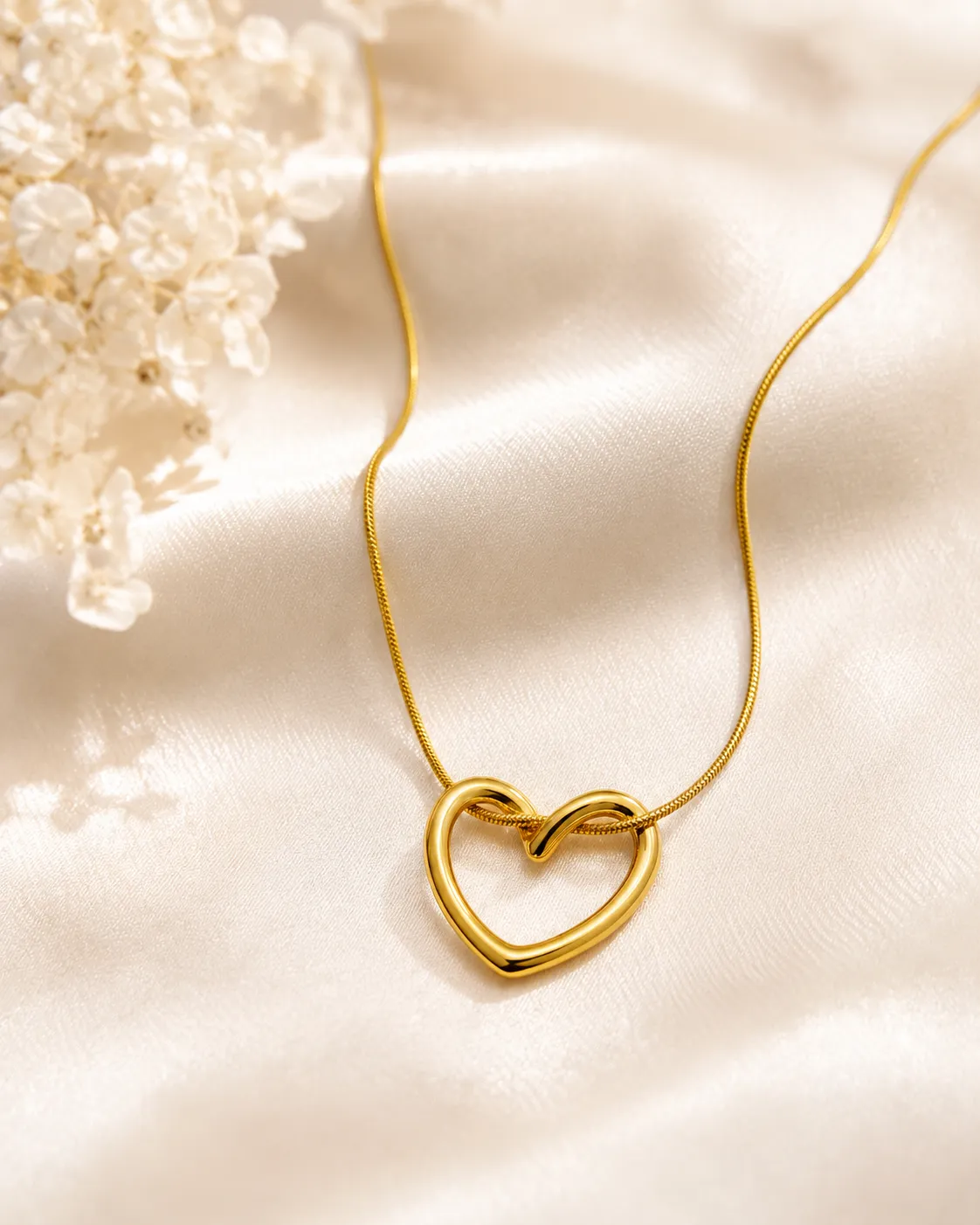 Open Heart Golden Necklace Open Heart Golden Necklace featuring a polished gold open heart pendant on a sleek snake chain