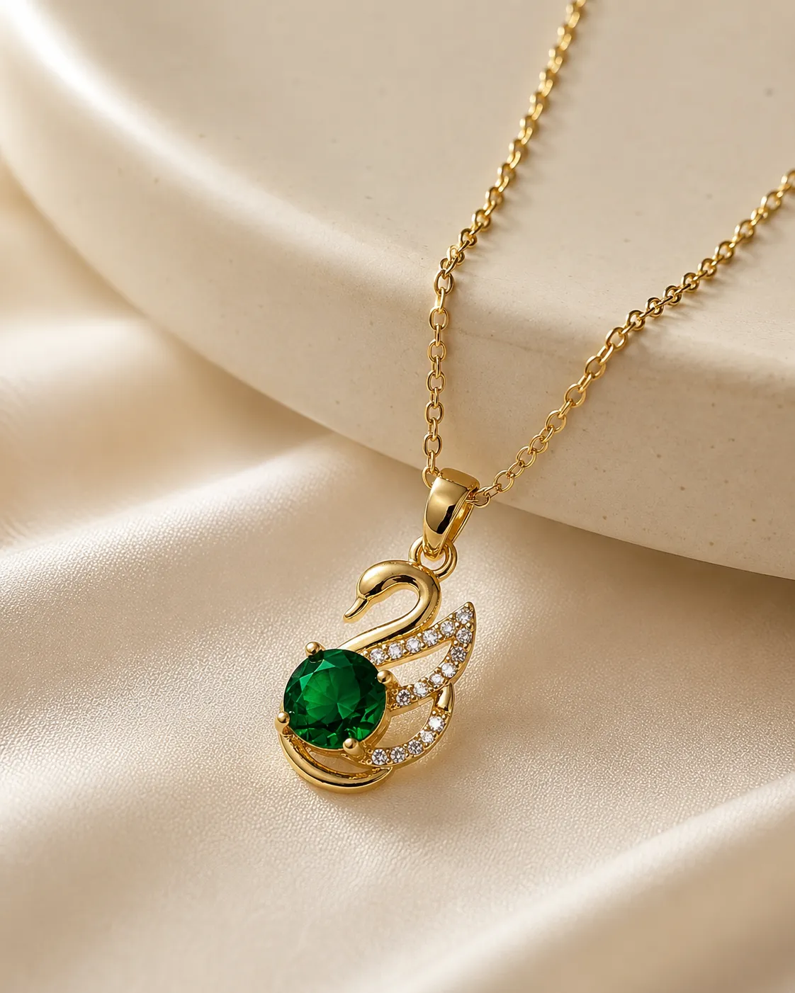Emerald Swan Pendant Necklace Emerald Swan Pendant Necklace featuring a green crystal and sparkling zirconia accents in a premium gold finish