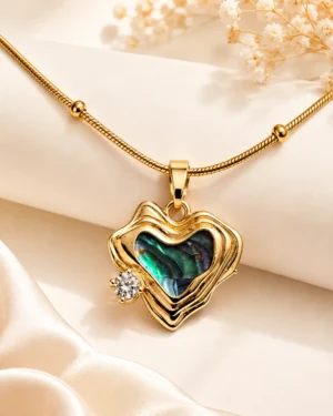 Heart of Sea Necklace featuring an iridescent ocean-inspired heart stone with a sparkling crystal accent in a premium gold finish