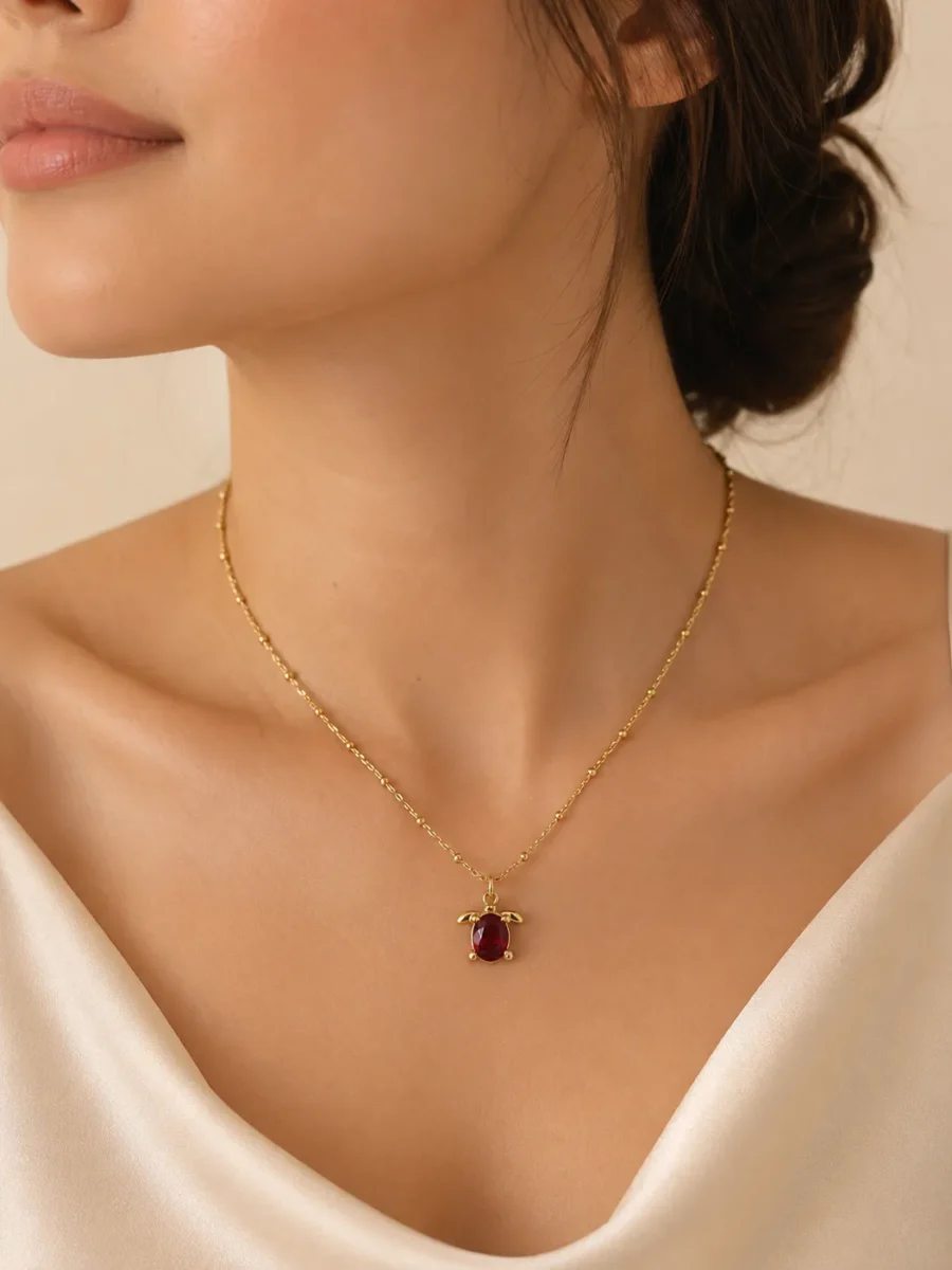 Ruby Turtle Pendant Necklace featuring a brilliant ruby-red crystal in a premium gold turtle design