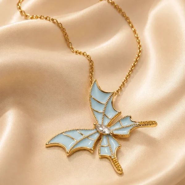 Sky Butterfly Pendant Necklace featuring blue enamel butterfly wings with a sparkling crystal center in a premium gold finish