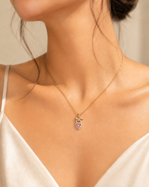 Pink Crystal Heart Necklace featuring a sparkling heart-cut pink crystal with crystal bow pendant in gold finish